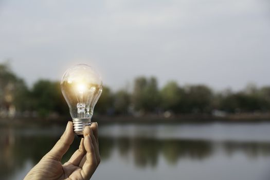 Hand holding a light bulb. Innovation and creative concept.