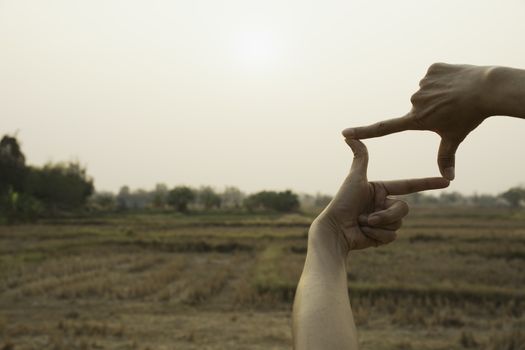 Hands making frame with sunset. Close up of woman hands making frame gesture.