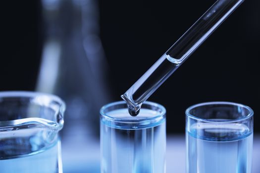 Researcher with glass laboratory chemical test tubes with liquid for analytical , medical, pharmaceutical and scientific research concept.