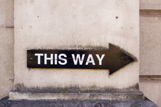 This way sign in black on a wall in Kendal