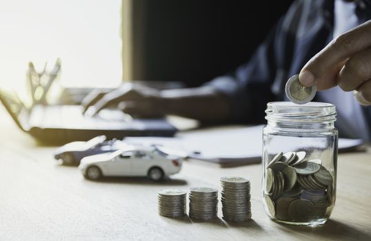 Car insurance and car service with stack of coins. Toy car for accounting and financial concept.