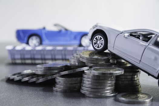Car insurance and car service with stack of coins. Toy car for accounting and financial concept.