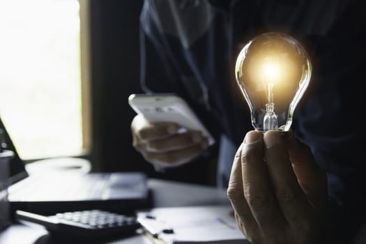 Hand of male holding a light bulb and copy space for accounting, ideas and creative concept.