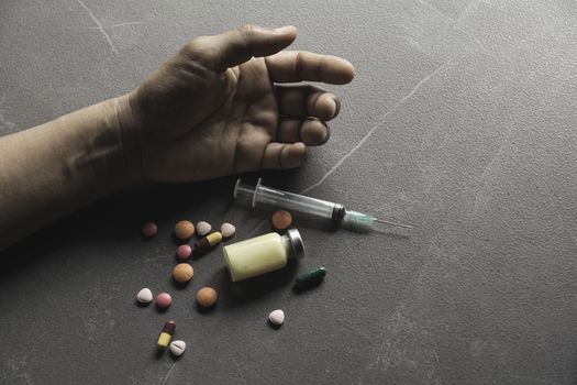 The man committing suicide by overdosing on medication. Close up of overdose pills and addict.