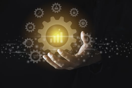 Hand of businessman holding gear icon for technology and business concept.