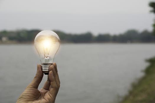 Hand of male holding a light bulb and copy space for accounting, ideas and creative concept.