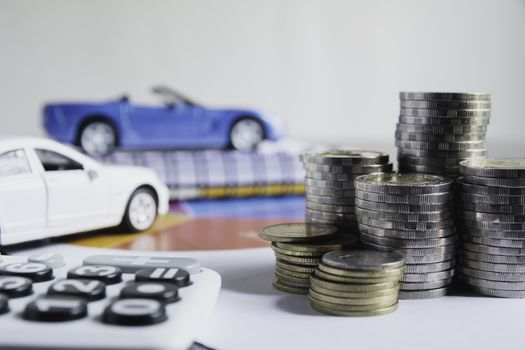 Car insurance and car service with stack of coins. Toy car for accounting and financial concept.
