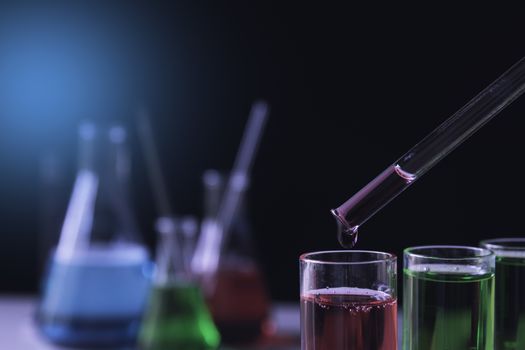 Researcher with glass laboratory chemical test tubes with liquid for analytical , medical, pharmaceutical and scientific research concept.