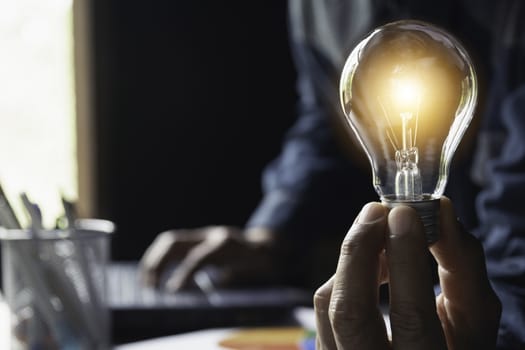 Hand of male holding a light bulb and copy space for accounting, ideas and creative concept.
