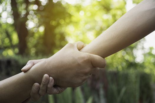 Friend holding hands together at outdoor. Hand holding between colleagues. Friendship and teamwork concept.