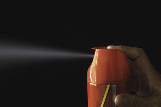 Hand holding mosquito spray. Human using mosquito spray from bottle.