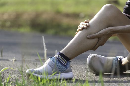 The female clings to a bad leg. The pain in her leg. Health and painful concept.