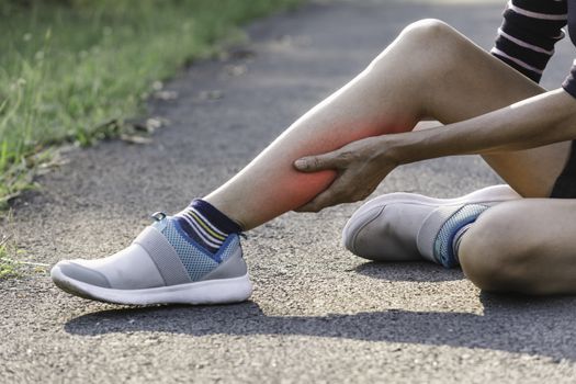 The female clings to a bad leg. The pain in her leg. Health and painful concept.