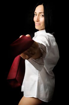 young woman with black hair and a Caucasian appearance is dressed in a white men's shirt and pulls a red tie over herself, low key