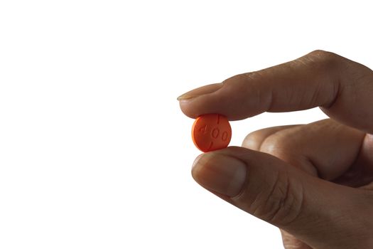 Hand holding a white pills isolated on white background.