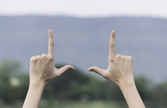 Close up of hands making frame gesture. Close up of woman hands making frame gesture with sunset.