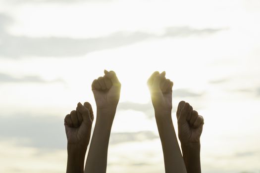 Hand of people fist raising up showing power strong with sky background.