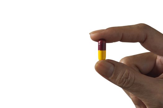 Hand holding a white pills isolated on white background.