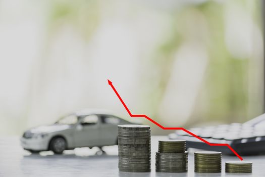 Car insurance and car service. Line graph with stack of coins and toy car, business and financial concept.