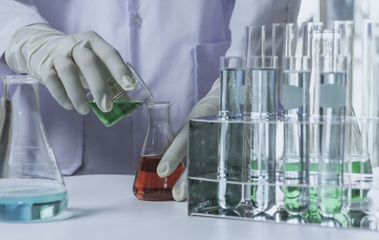 Researcher with glass laboratory chemical test tubes with liquid for analytical , medical, pharmaceutical and scientific research concept.