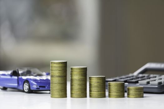 Car insurance and car service. Line graph with stack of coins and toy car, business and financial concept.