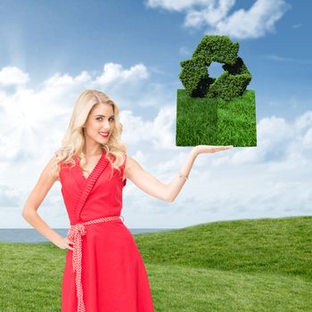 Woman holding lawn book against green field under blue sky