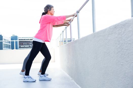Women leaning on railing while exercising outdoors