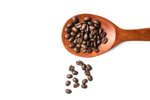 A wooden spoon with spread coffee beans isolated on white background and copy space