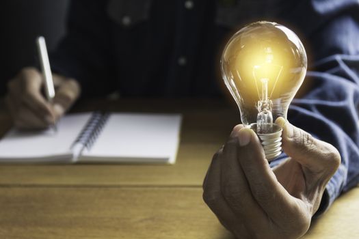 Hand of male holding a light bulb and copy space for accounting, ideas and creative concept.