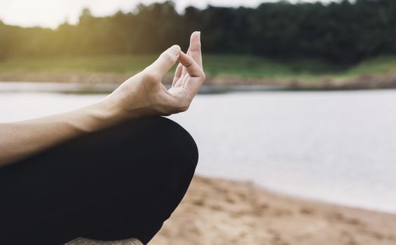Woman meditating at near river for lifestyle relaxation emotional concept.