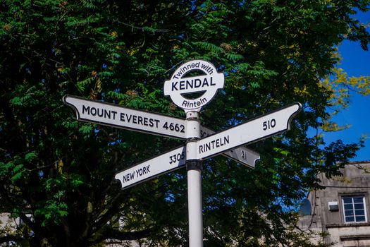 Town signpost showing directions to various places in the center of historical town Kendal. Kendal is considered as the southern gateway to the Lake District, UK