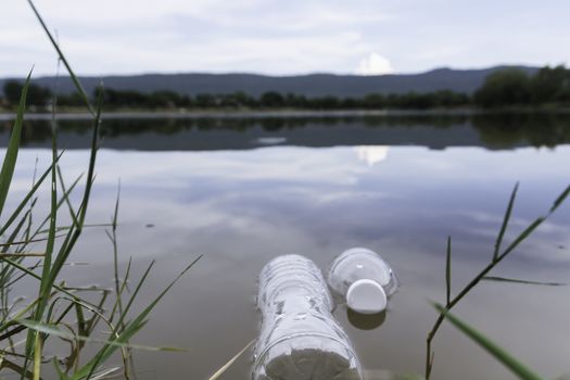 Plastic water bottles pollution in the river. Plastic trash in water. Environmental pollution concept.