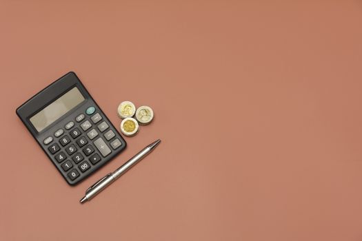 Stack of coin and calculator with copy space. Accounting and business concept.