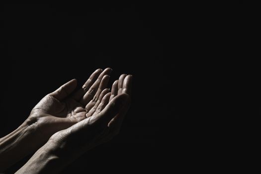 Hand of man while praying for religion. Concept peace and life.