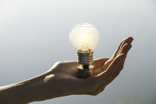 Hand of male holding a light bulb and copy space for energy, ideas and creative concept.