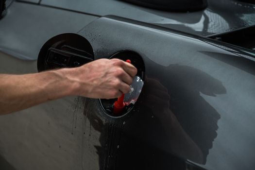 Detailer using a brush on a car during washing