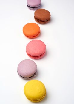 multi-colored baked macaroons from almond flour on a white background, selective focus