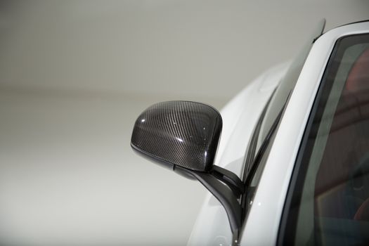 Carbon fibre mirror car on white sports car