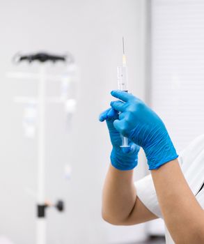 the doctor prepares a syringe with an injection, close-up