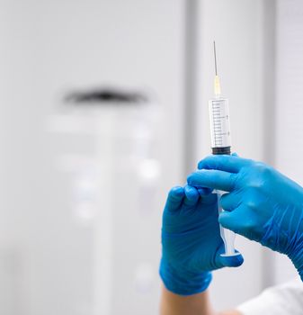 the doctor prepares a syringe with an injection, close-up