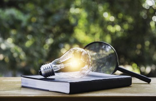 Light bulb and a book on table and copy space for insert text.