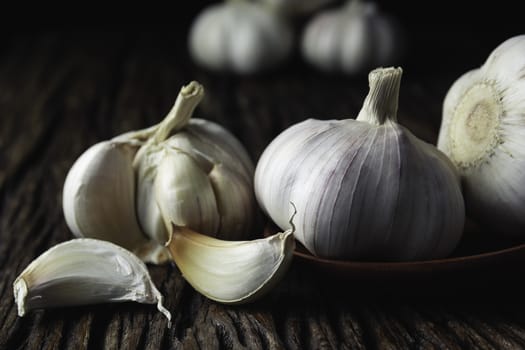 Fresh white garlic on wooden table with black background. Food and healthy concept. 