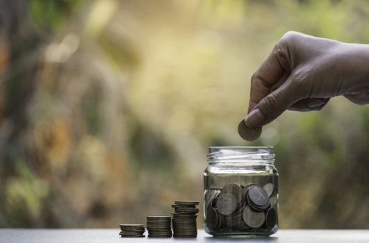 Hand drop a coin with money coin stack growing for business. financial and accounting concept.