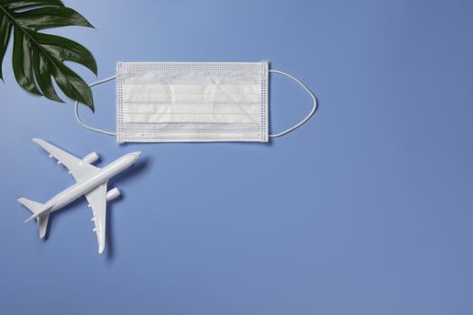 A toy airplane with medical mask for protecting virus and dust. Travel and protection concept.