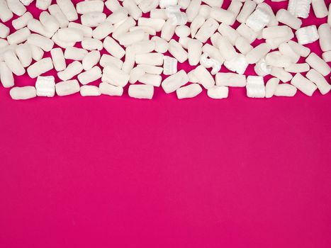 white foam filler for filling parcels during transportation on a pink background, copy space