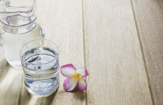 Water glass with glass jar on wooden table. Glass and clean drinking water with copy space.