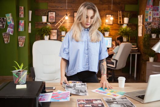 Businesswoman in creative office looking at drawings. Female designer.