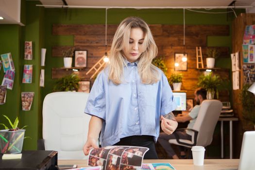 Creative female designer in her office with coworker in the background.