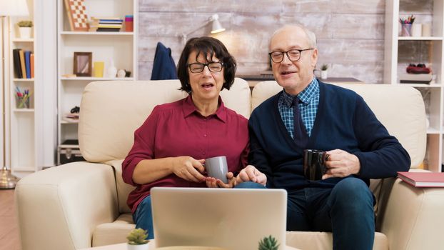 Couple of old people using modern technology. They are on a video call using laptop