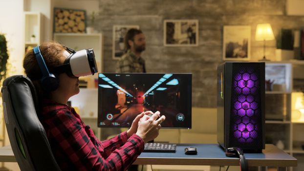Woman relaxing playing video games using vr headset. Game over for female gamer. Man in the background.